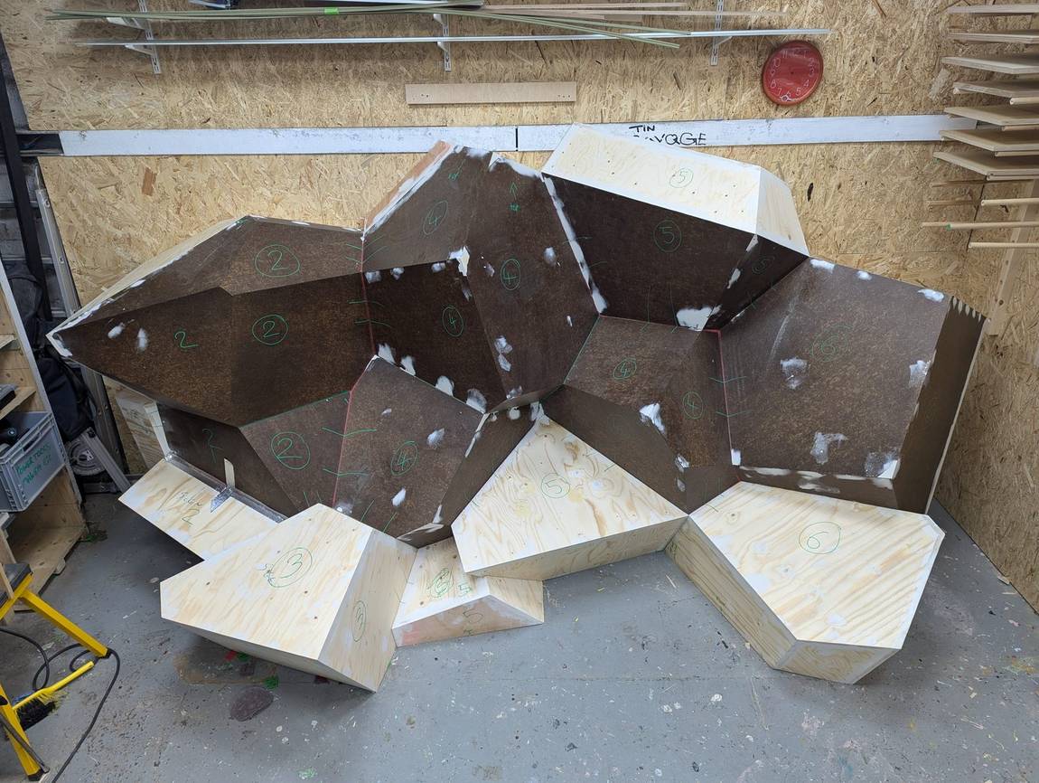 The plywood subframe under construction in the workshop, panels numbered for assembly