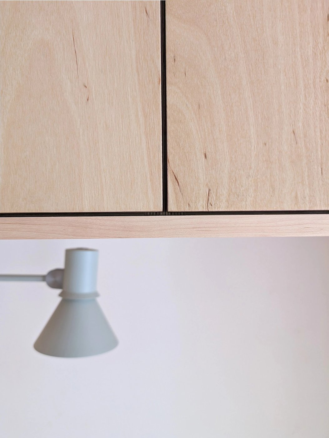 Close-up of a panel joint, with the wall lamp mounted in the nook below