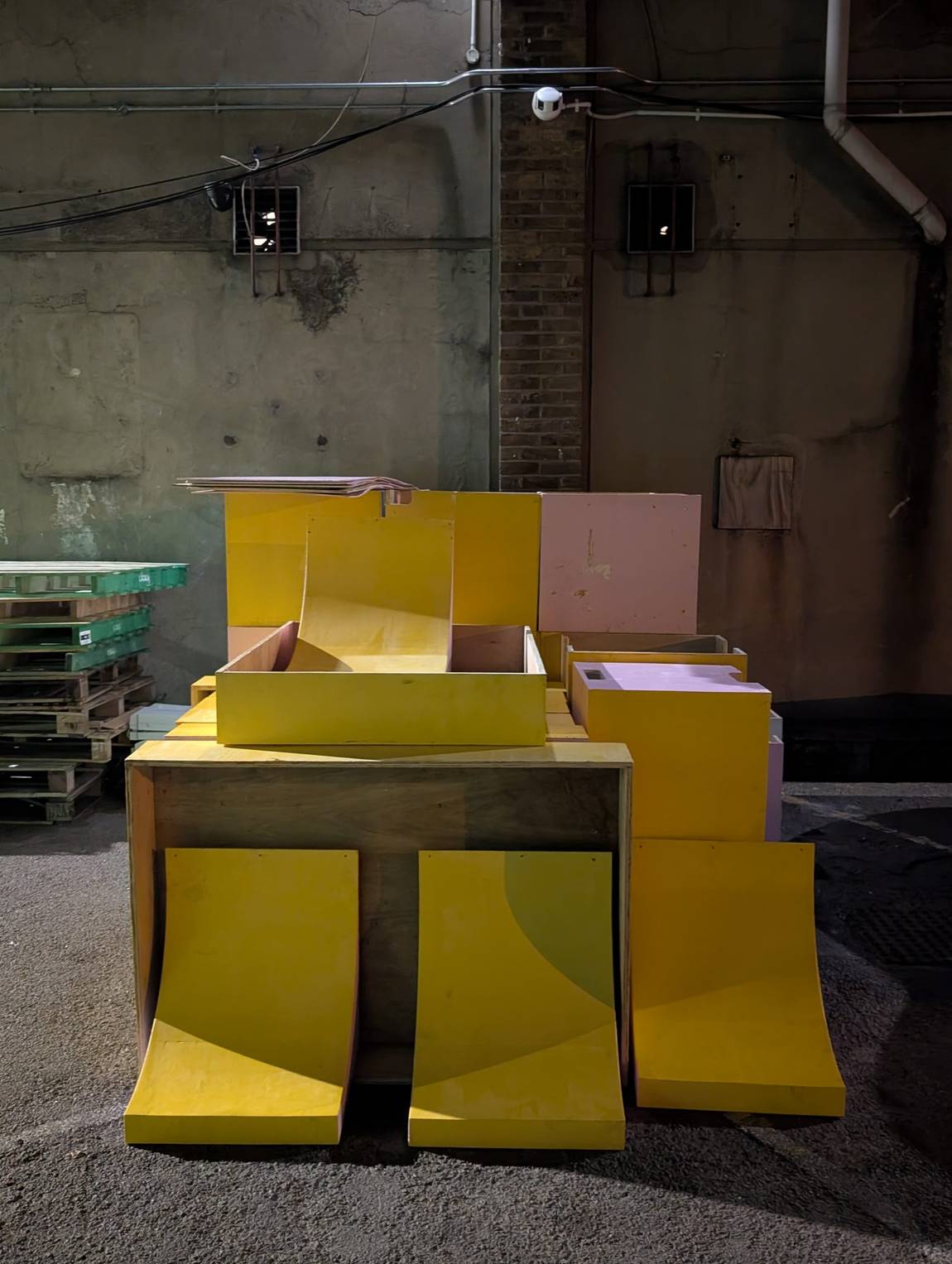 The marine-ply boxes under construction in the workshop, in the market's yellow and pink