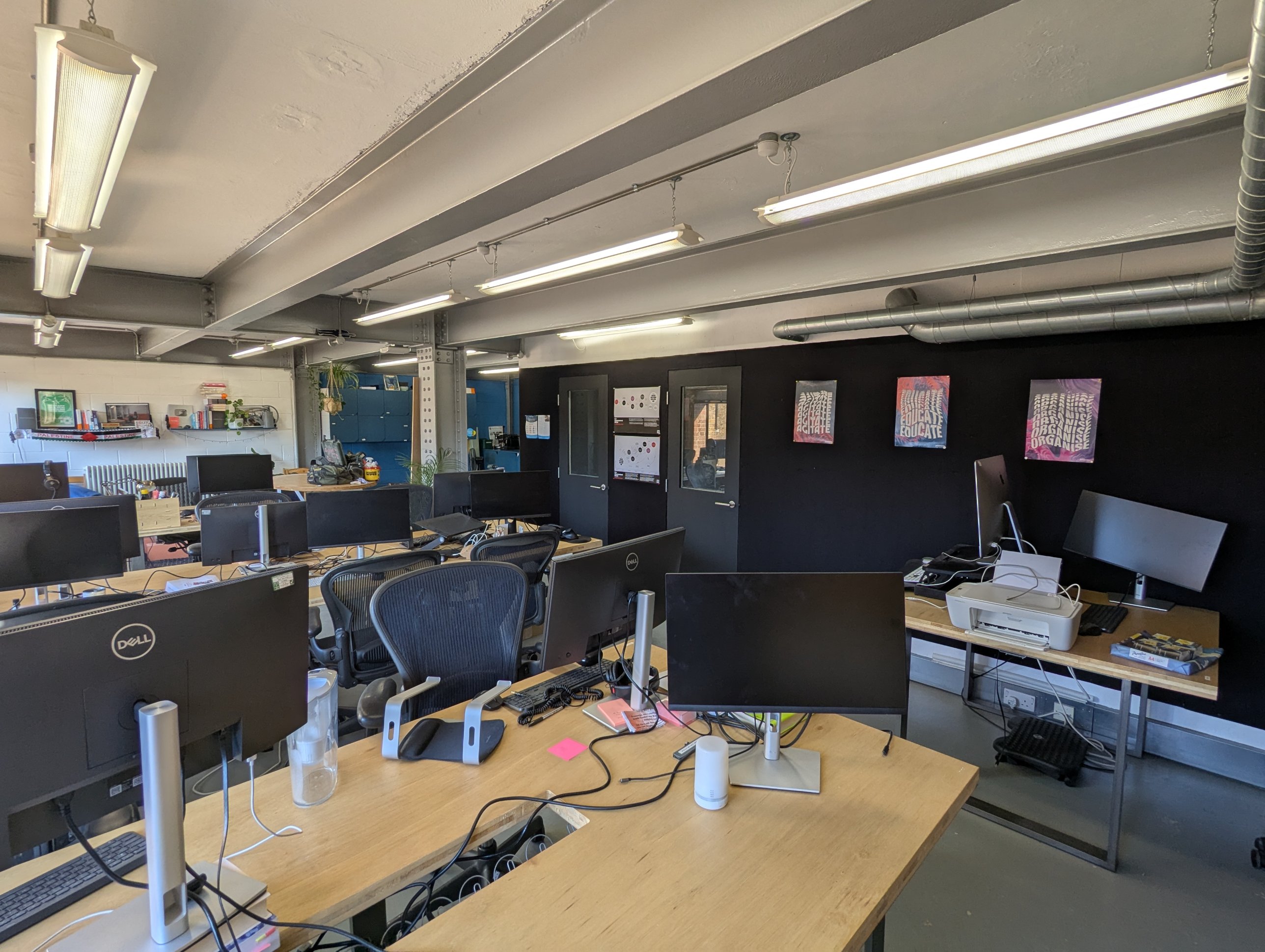 Wide view of the open-plan office, with the desk run and the meeting rooms beyond