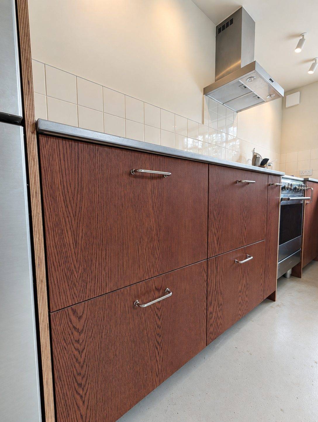 Close-up of the oak-veneered drawer and cupboard fronts, beside the range and extractor