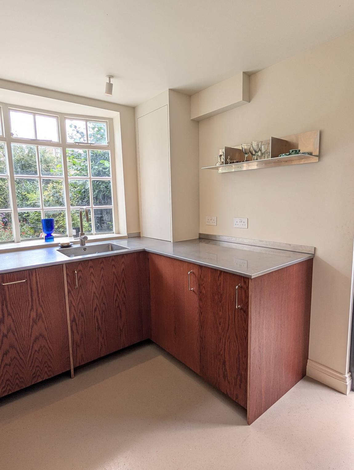 The full run of cabinetry from the sink to the neutral boiler cupboard, with the bay window beyond