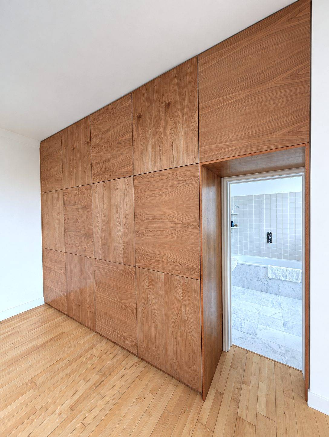 Angled view of the wardrobe wall and the en-suite doorway